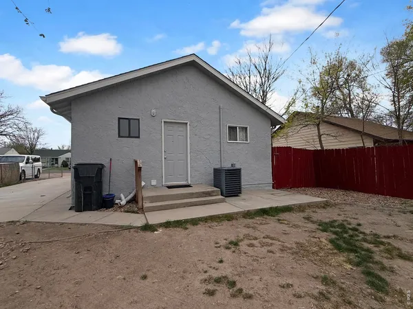 a white house that has a tree in front of it