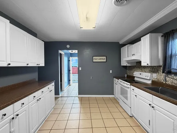 a kitchen with a refrigerator a sink and cabinets
