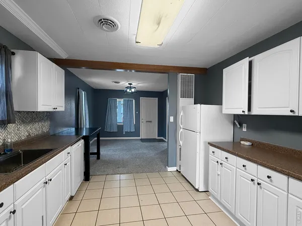 a kitchen with granite countertop white cabinets and white appliances