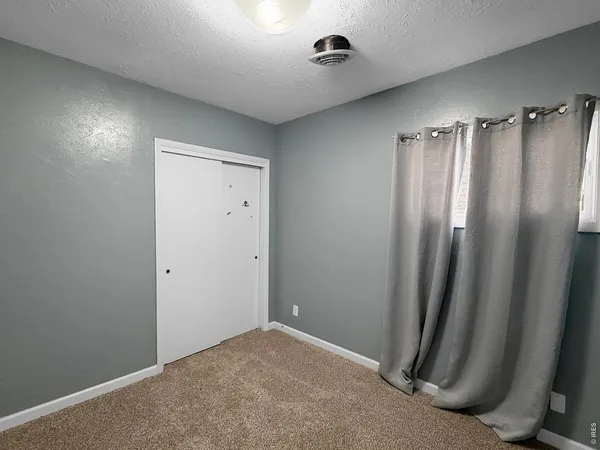 an empty room with closet and entryway
