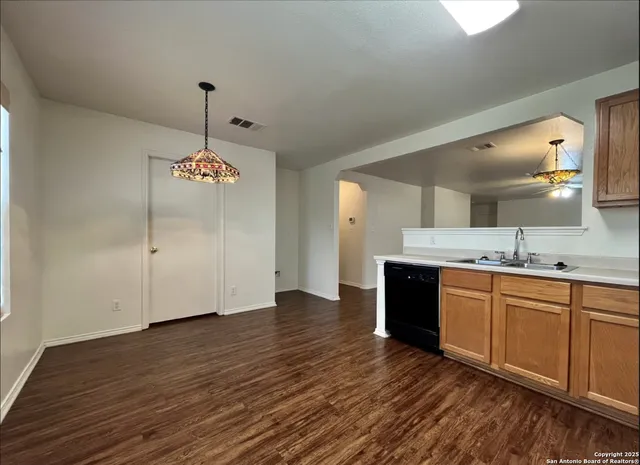 a large kitchen with stainless steel appliances granite countertop a sink and a wooden floor