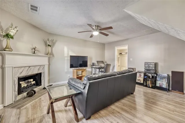 a living room with furniture a fireplace and a flat screen tv
