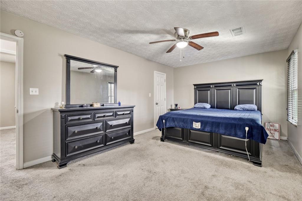 5544 Alpine Court Lithonia, GA 30038 - Photo 13 of 28 a bedroom with a bed and a chandelier