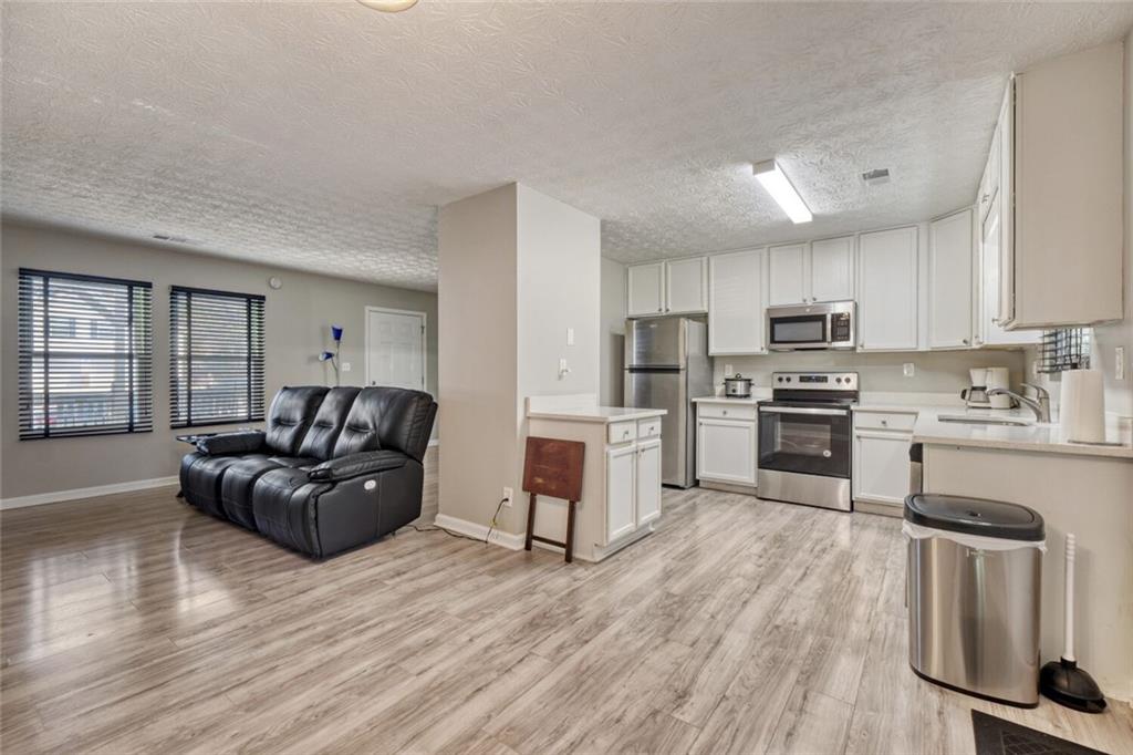 5544 Alpine Court Lithonia, GA 30038 - Photo 7 of 28 a living room with stainless steel appliances furniture and a wooden floor