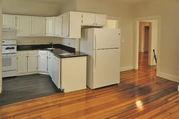 a kitchen with a refrigerator and a stove top oven
