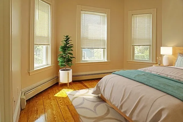 a spacious bedroom with a bed and next to a window