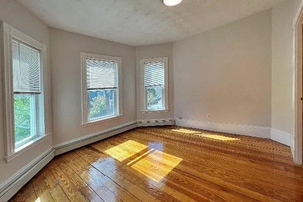 a view of a room with wooden floor and natural light