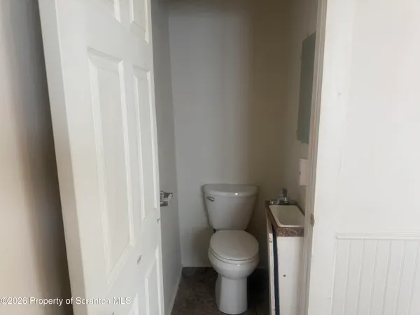 a white toilet sitting next to a shower