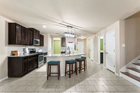 a kitchen with stainless steel appliances granite countertop a stove top oven a sink dishwasher and a refrigerator