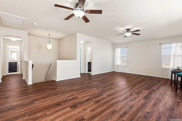a view of an empty room with a window and wooden floor