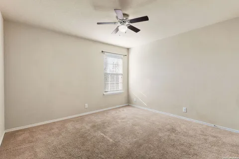 an empty room with a window and a ceiling fan