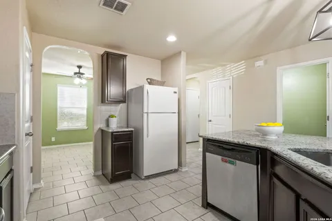 a kitchen with granite countertop a refrigerator and a sink