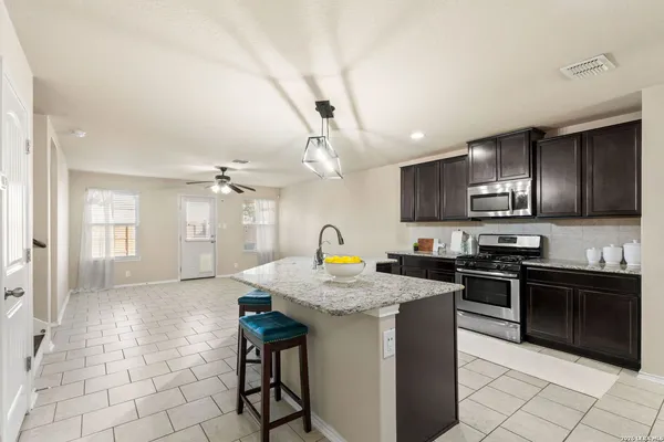 a kitchen with stainless steel appliances granite countertop a stove a sink dishwasher a microwave oven with granite countertops and cabinets