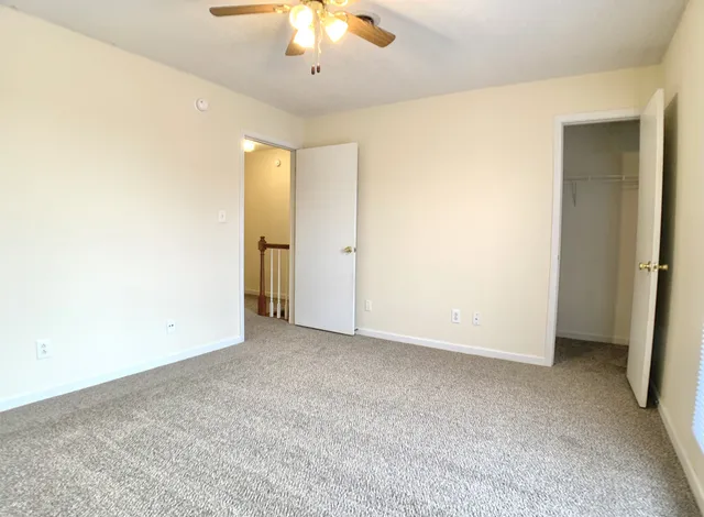 an empty room with chandelier fan