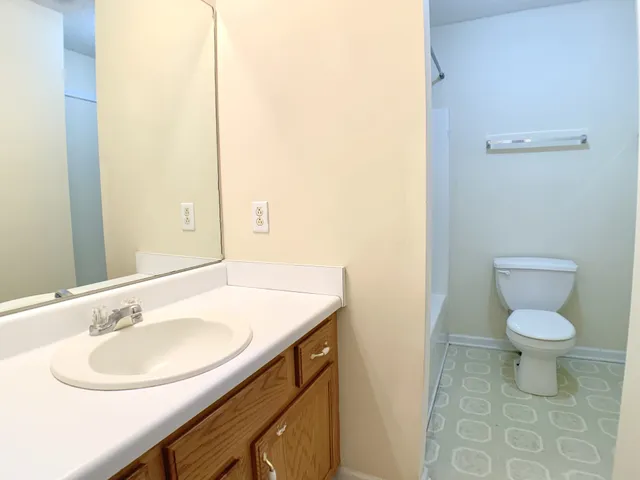 a bathroom with a sink toilet and a mirror