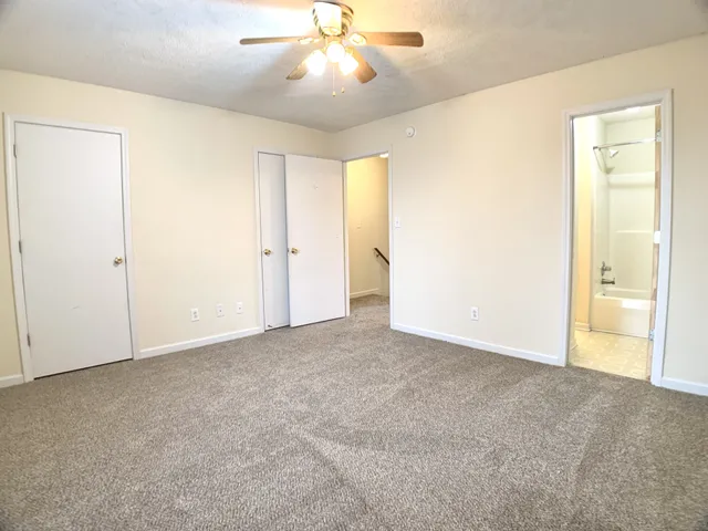 an empty room with closet and a chandelier fan