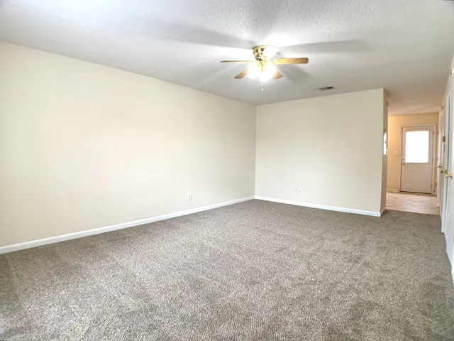an empty room with a chandelier fan