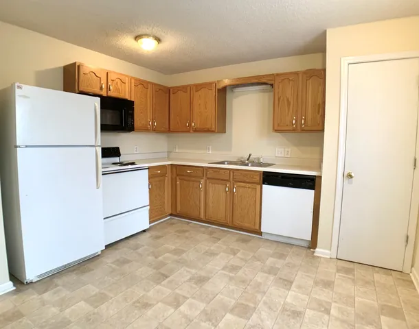 a kitchen with stainless steel appliances granite countertop a stove a sink dishwasher a refrigerator and a refrigerator