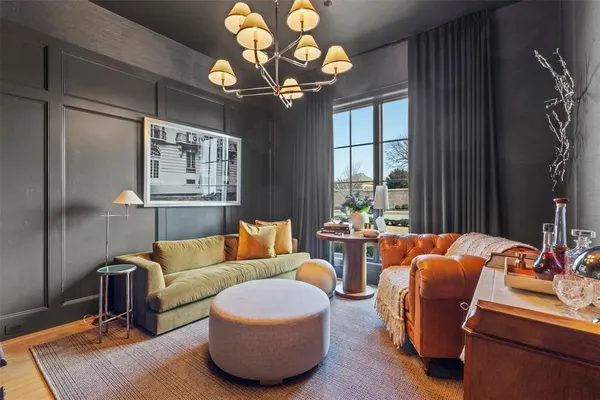 a living room with furniture a chandelier and a large window