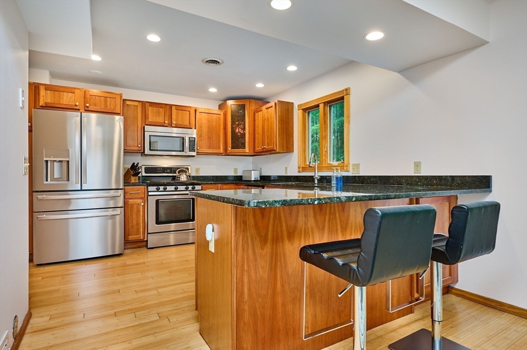 88 High Point Drive Amherst, MA 01002 - Photo 13 of 35 a kitchen with stainless steel appliances granite countertop a refrigerator a stove and a sink with wooden floor