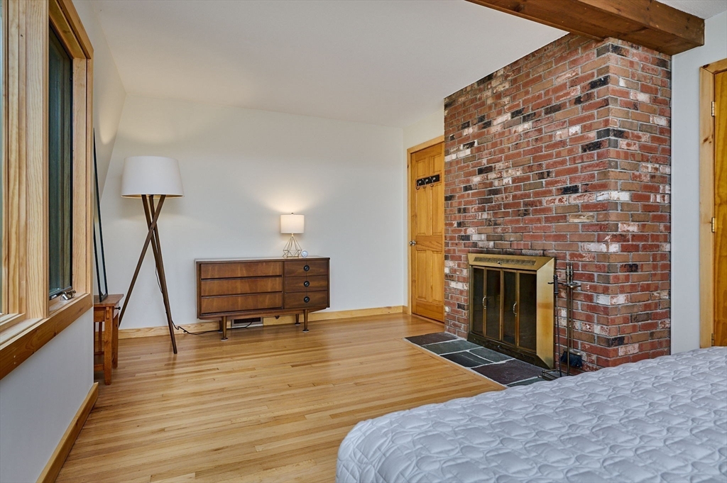 88 High Point Drive Amherst, MA 01002 - Photo 18 of 35 a living room with furniture a fireplace and a floor to ceiling window