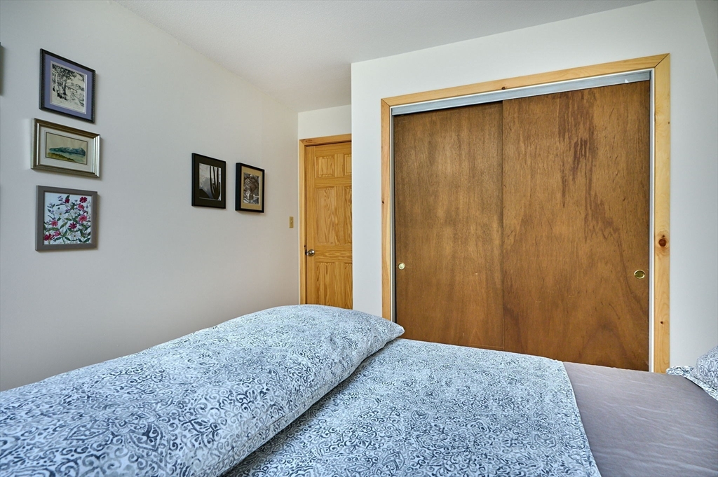 88 High Point Drive Amherst, MA 01002 - Photo 24 of 35 a bedroom with a bed and paintings on the wall