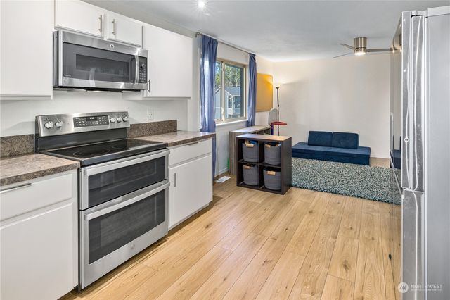a kitchen with stainless steel appliances kitchen island granite countertop a stove and a sink