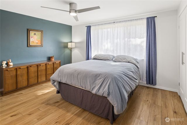 a bedroom with a bed and a wooden floor