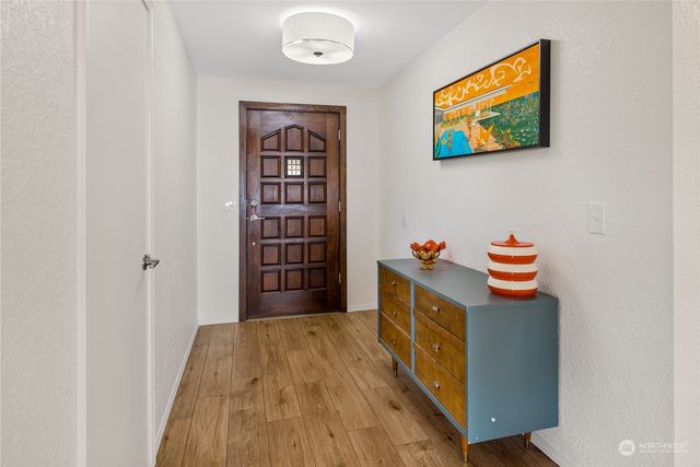 a kitchen with stainless steel appliances a stove and a painting on the wall