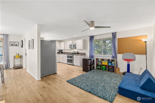 a living room with furniture and a open kitchen view