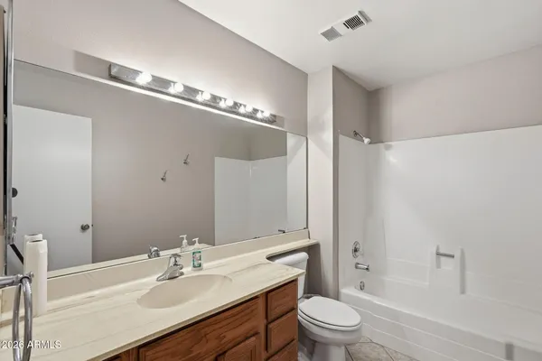a bathroom with a sink a toilet a mirror and shower