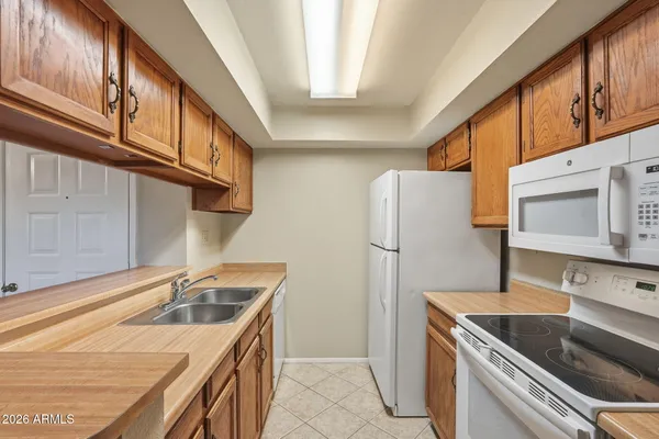 a kitchen with stainless steel appliances granite countertop a sink and a refrigerator