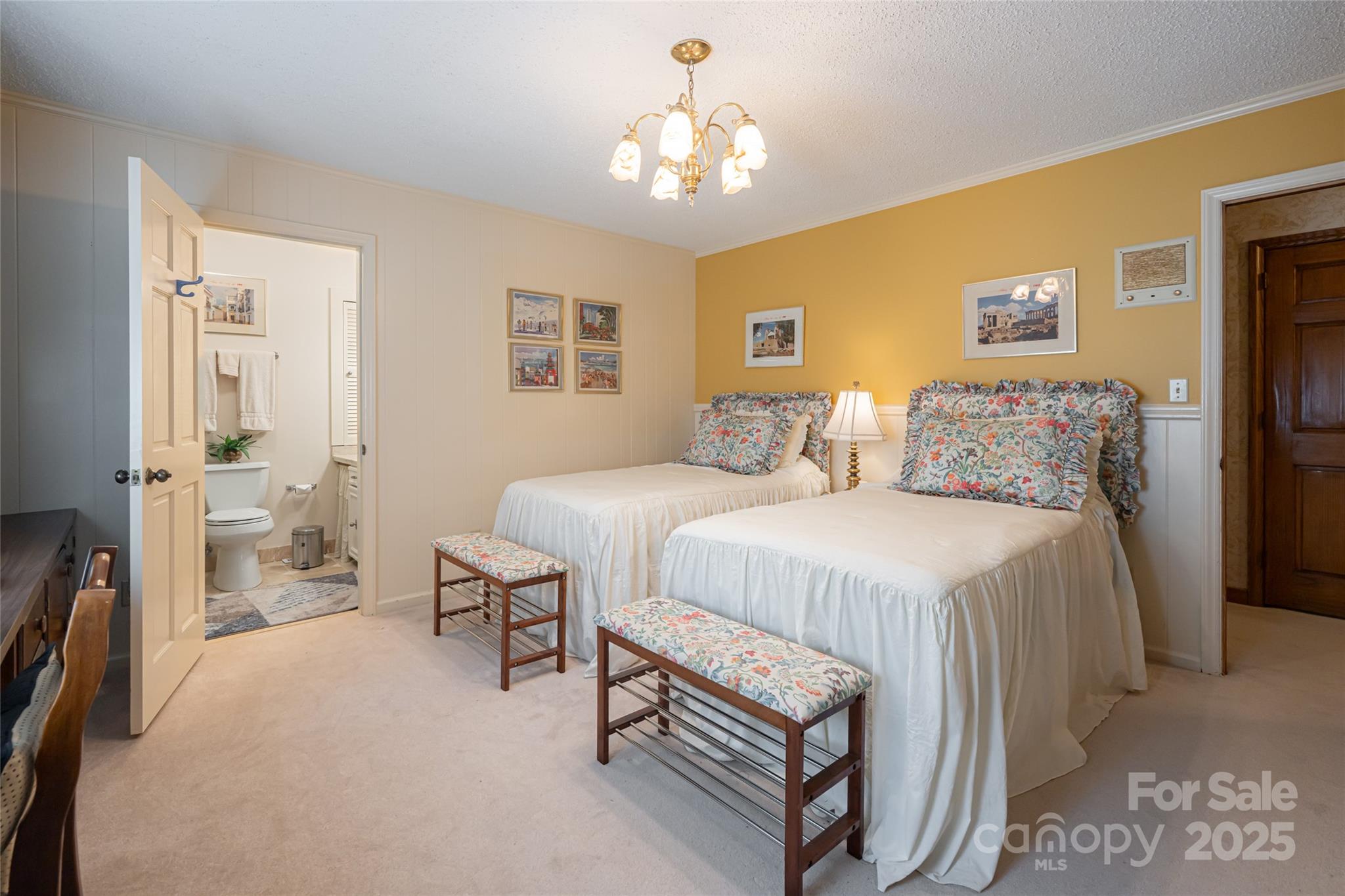 69 Forest Road Asheville, NC 28803 - Photo 21 of 48 a spacious bedroom with a bed and a chandelier