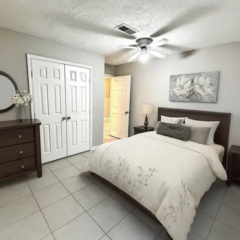 a spacious bedroom with a bed and a chandelier