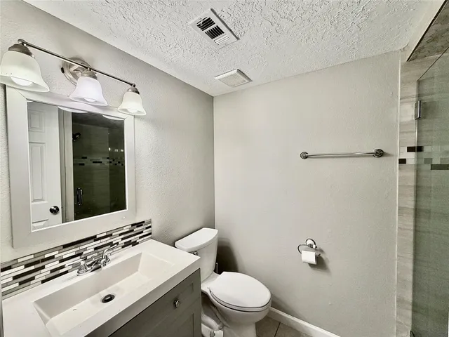 a bathroom with a sink mirror and toilet