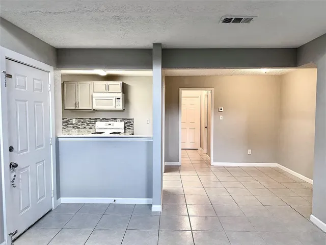 a view of kitchen with granite countertop cabinets