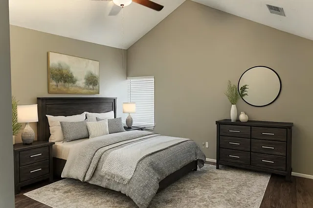 a bedroom with a bed a mirror on dresser and a chandelier