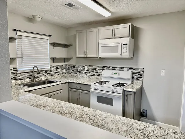 a kitchen with white cabinets sink and stainless steel appliances