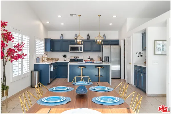 a kitchen with stainless steel appliances kitchen island granite countertop a dining table and chairs