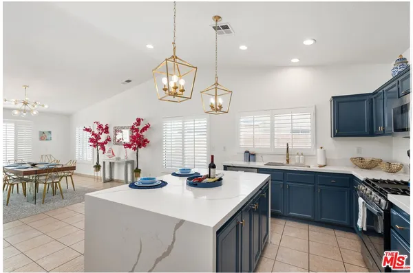a kitchen with granite countertop a sink cabinets and stainless steel appliances