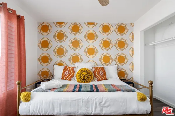 a bedroom with a bed and a painting on the wall