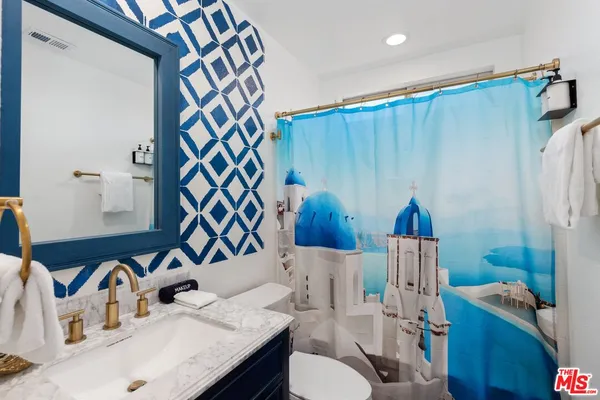 a bathroom with a sink a toilet and shower curtain