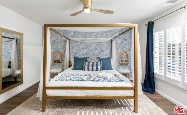 a bedroom with a bed a chandelier and large window