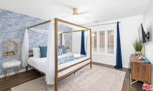 a bedroom with a bed and large windows