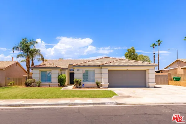 a front view of a house with a garden and yard