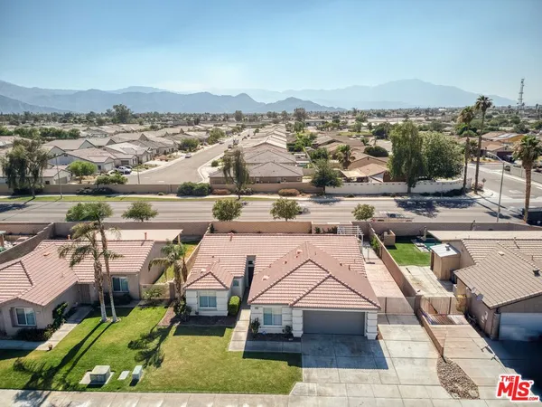 an aerial view of residential houses with outdoor space and ocean view
