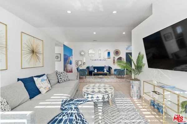 a living room with furniture a flat screen tv and a fireplace