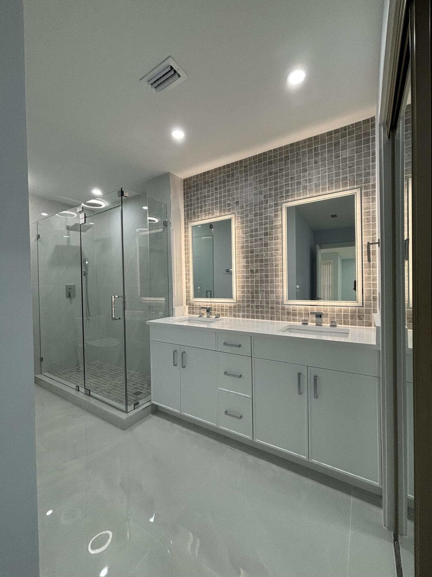 9266 Vista Del Lago, Unit 25H Boca Raton, FL 33428 - Photo 24 of 38 a spacious bathroom with double vanity and a mirror