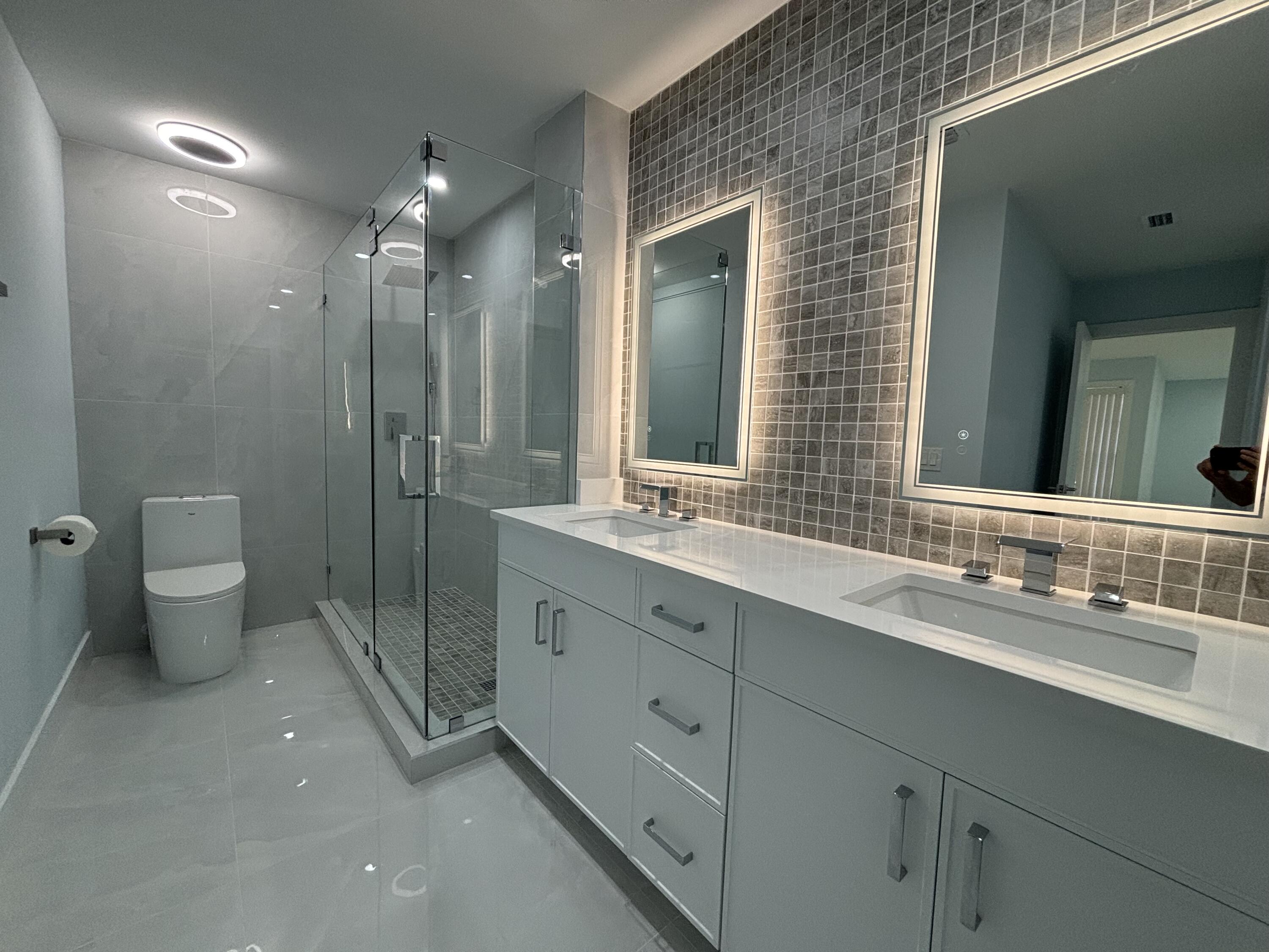 9266 Vista Del Lago, Unit 25H Boca Raton, FL 33428 - Photo 25 of 38 a bathroom with a double vanity sink toilet and shower