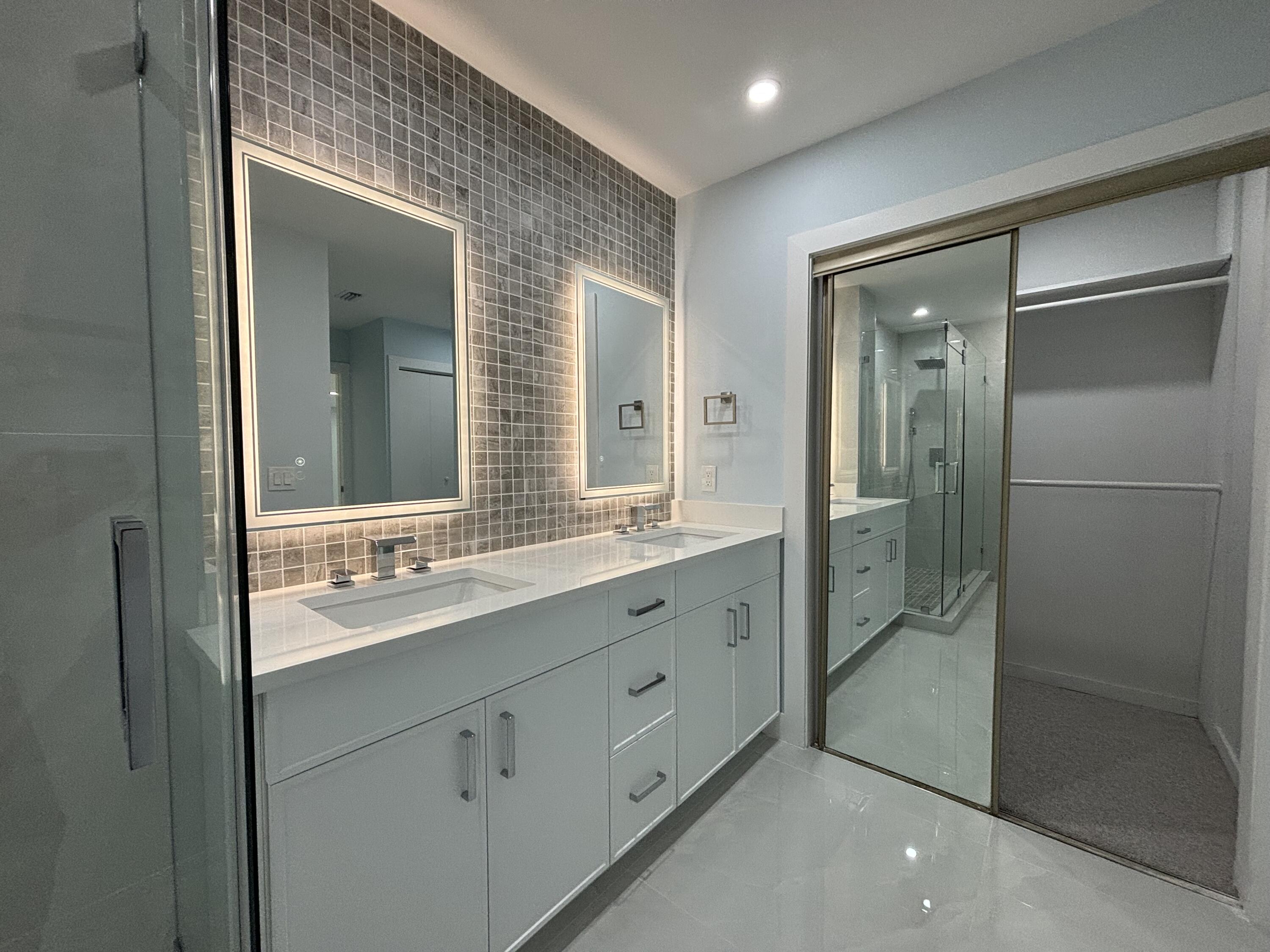 9266 Vista Del Lago, Unit 25H Boca Raton, FL 33428 - Photo 26 of 38 a bathroom with a double vanity sink mirror and shower